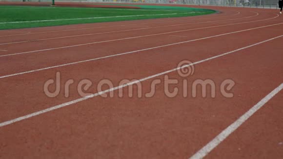 女子在体育场跑道上跑步视频的预览图