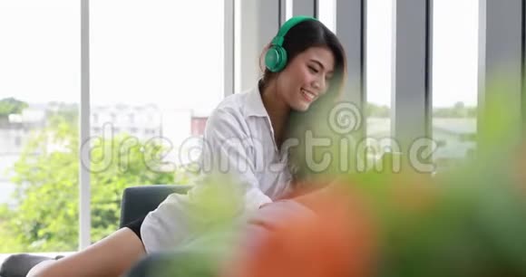 亚洲女人听她的智能手机音乐视频的预览图