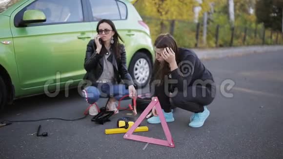 两个女人在路边的破车旁打电话求救视频的预览图