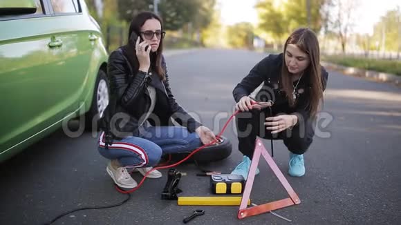 路上的问题汽车的故障打电话给技术援助两个女人靠近一辆破车视频的预览图