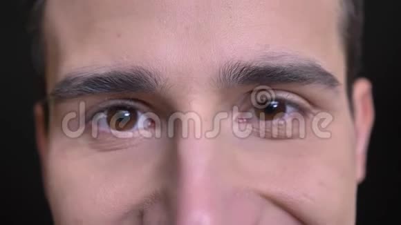 年轻的白种人男性面部特写镜头棕色眼睛直视镜头面部表情微笑视频的预览图