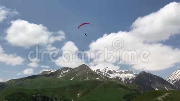 白种人绿山中的滑翔伞美景视频的预览图