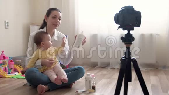 年轻的母亲带着小男孩在摄像机上录制视频并对家庭和童年进行录像视频的预览图