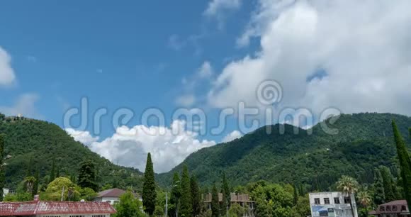 群山中的一个小村庄有着美丽的积云夏天在群山中流逝一个美丽的村庄视频的预览图