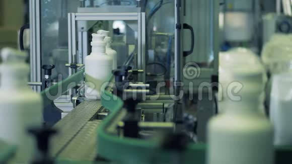 装有化学物质的瓶子在金属输送机上移动工厂设备视频的预览图