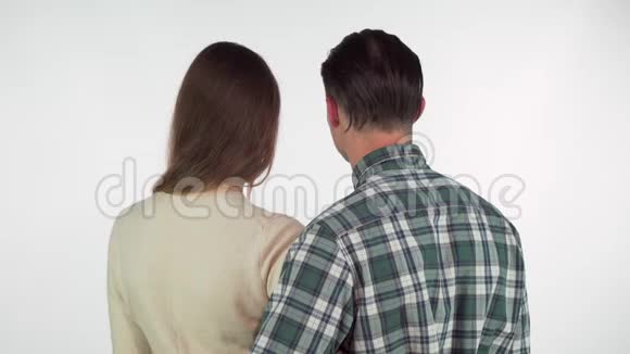 后景拍摄一对夫妇拥抱转向镜头在他们的肩膀上视频的预览图