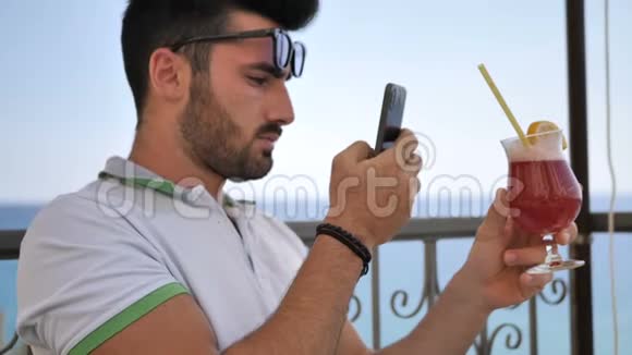 男子拍摄他的鸡尾酒夏天在酒吧室外视频的预览图