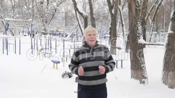 一位欧洲老人在冬天做一个早上的户外热身当场跑步健康的生活理念60英尺视频的预览图
