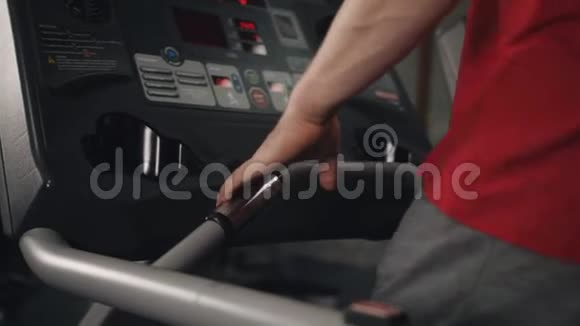 男子在健身房跑步机上慢跑的特写镜头和他在屏幕上看到的监控信息视频的预览图