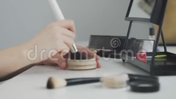 化妆品背景上专业化妆粉的宽刷视频的预览图
