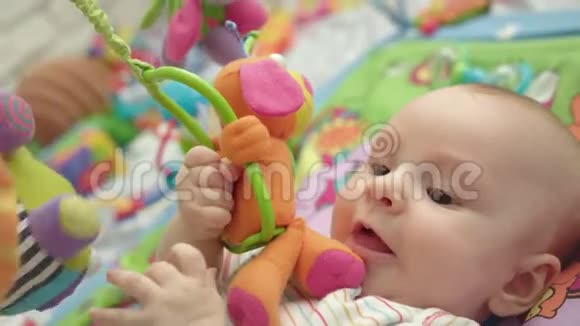 可爱的宝宝啃玩具可爱的父母可爱的男孩拨浪鼓视频的预览图