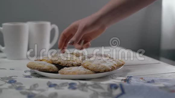 特写方向女人手从桌子上拿饼干和一杯茶视频的预览图