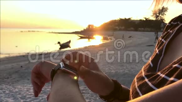 智能手表年轻女子在海滩上使用智能手表视频的预览图