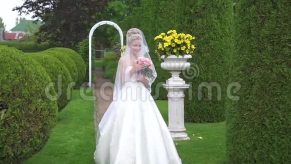 一位美丽的新娘在绿色公园里捧花的肖像英国风格视频的预览图