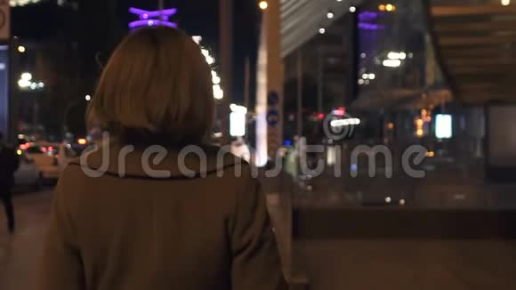 优雅的女人走回头路在灯火通明的城市享受傍晚的长廊视频的预览图