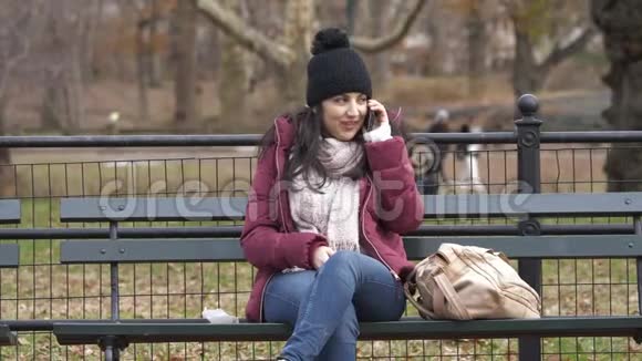 坐在纽约中央公园的长椅上打电话视频的预览图