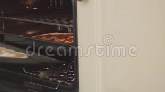 厨师把比萨饼放进电烤箱的手合上男人把披萨放在热锅里的烤盘上食物视频的预览图