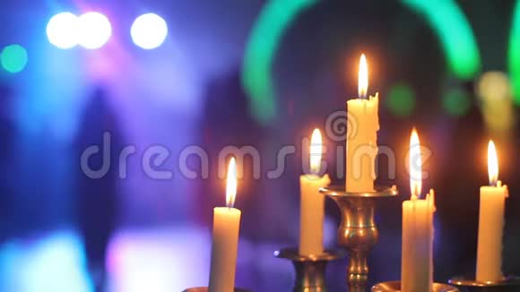 餐厅桌子上装饰蜡烛在燃烧蜡烛的背景下跳舞的人们视频的预览图