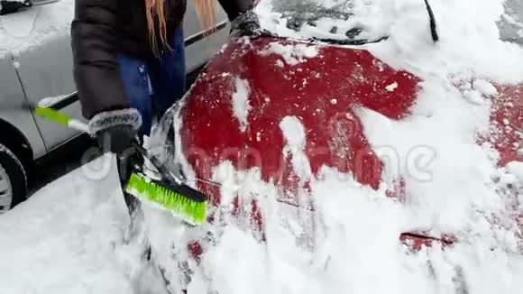 4k视频美丽的女司机早晨在暴风雪后清理汽车视频的预览图