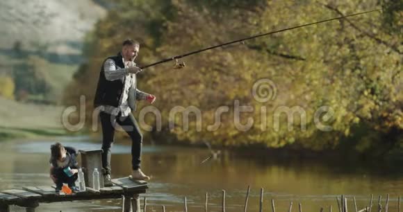 家庭时间在湖爸爸和他的小儿子一起钓鱼在晴天视频的预览图