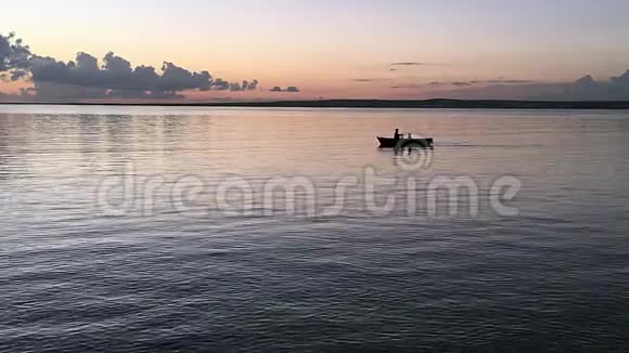 父子在划艇里日落时两个人划船的剪影视频的预览图