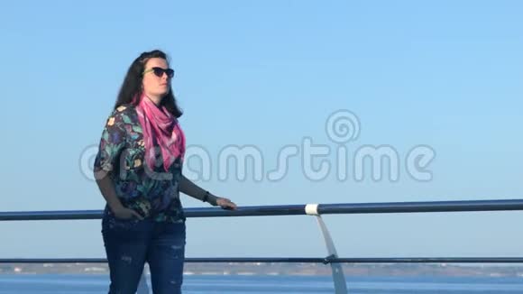 4美丽的女人走在码头上蓝色平静的大海在一边特写镜头视频的预览图