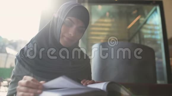 自信的阿拉伯女士在咖啡馆读书教育和自我发展视频的预览图