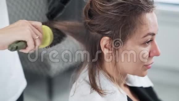 理发师给女性理发后用吹风机擦干湿发慢动作视频的预览图