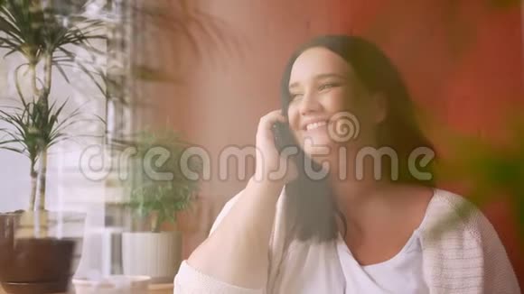 一个很有趣的白种人女孩在电话里聊天在室内大笑视频的预览图