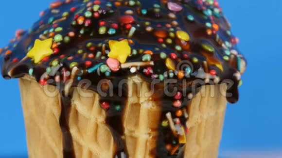 巧克力酱糖霜和五颜六色的糖霜在粉红色背景的华夫饼杯中流过冰淇淋视频的预览图