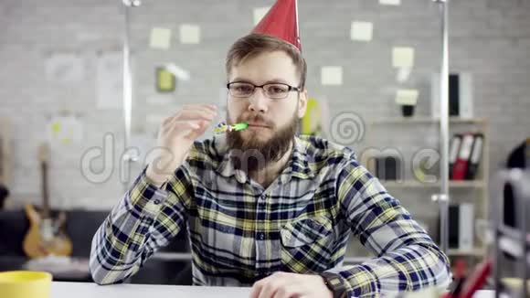 悲伤的心吸引了一位商人在办公室里庆祝一个孤独的生日他在一个小蛋糕上吹着蜡烛视频的预览图