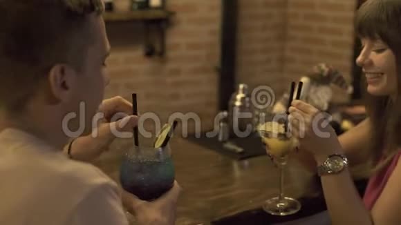 情侣恋爱中的男人和女人喝着酒精鸡尾酒坐在酒吧柜台在餐馆浪漫约会青年视频的预览图