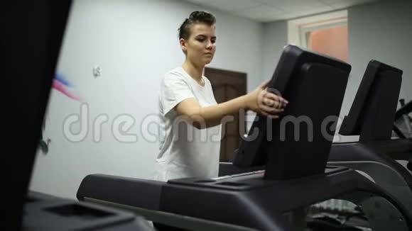 女孩在健身房的跑步机上加速视频的预览图