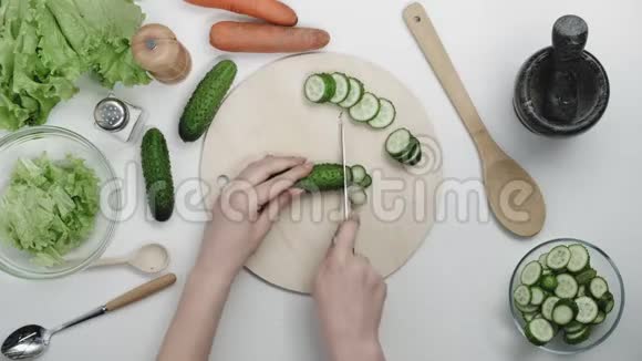 女性主管在厨房制作沙拉健康食品和在砧板上切黄瓜的俯视图视频的预览图