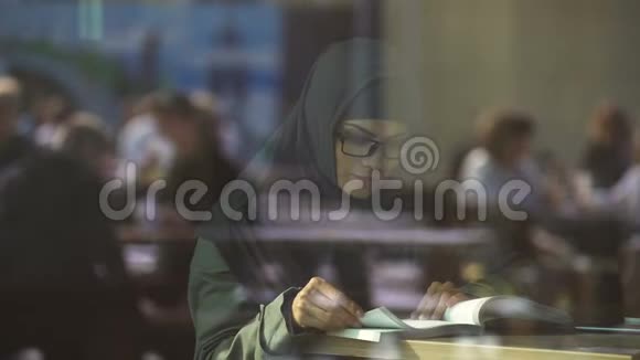 咖啡馆里的年轻阿拉伯语女士读书准备考试的学生文学视频的预览图