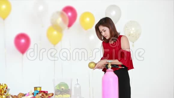 穿红色衬衫的亚洲女人用气球泵视频的预览图