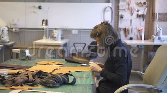 女皮革工人在工作室生产袋件的肖像视频的预览图