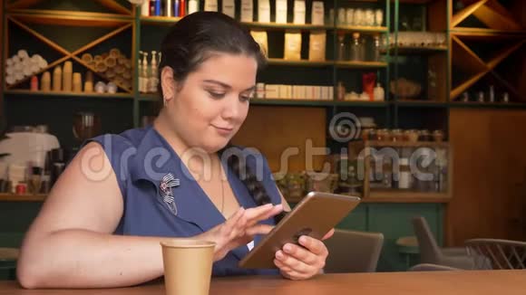 大白种人微笑的女孩在桌子上挥舞着她的计划喝着咖啡视频的预览图