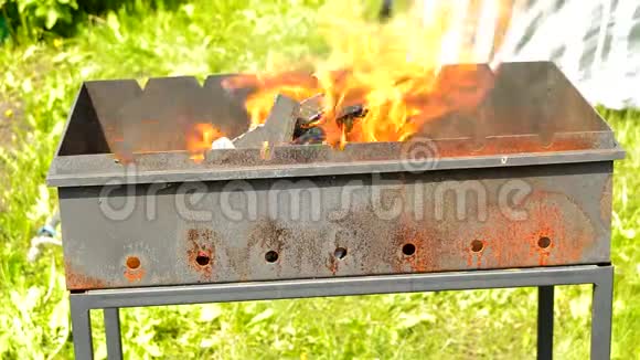 在室外的金属壁炉里燃烧木头时会有明亮的火焰烧烤用的火和煤自然会有黄色的火视频的预览图