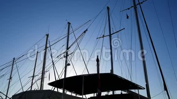 站在港口的船只桅杆的剪影太阳前的游艇视频的预览图