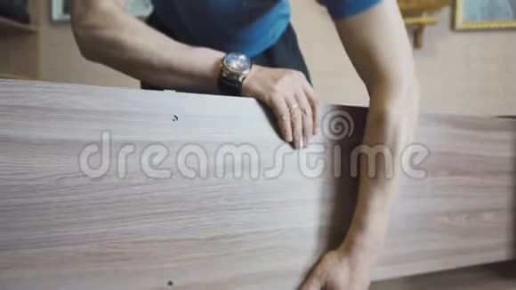 工人用螺丝刀和特殊螺丝组装和扭转木桌视频的预览图