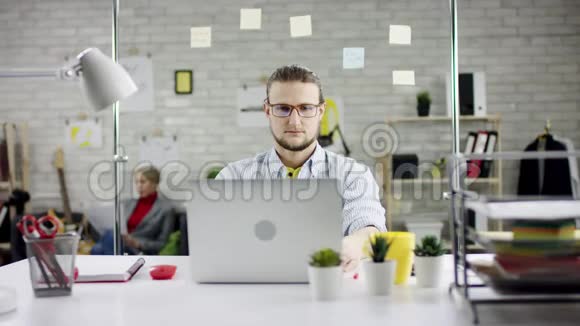 工作认真集中的商人靠后整理办公室的笔记本电脑有效的经理满意视频的预览图