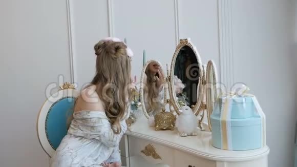 早晨美丽的女孩穿着睡衣在镜子前打扮视频的预览图