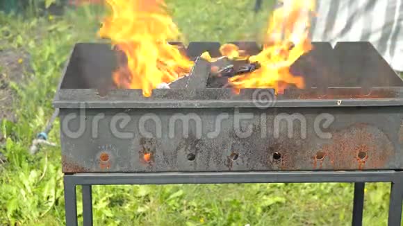在室外的金属壁炉里燃烧木头时会有明亮的火焰烧烤用的火和煤自然会有黄色的火视频的预览图