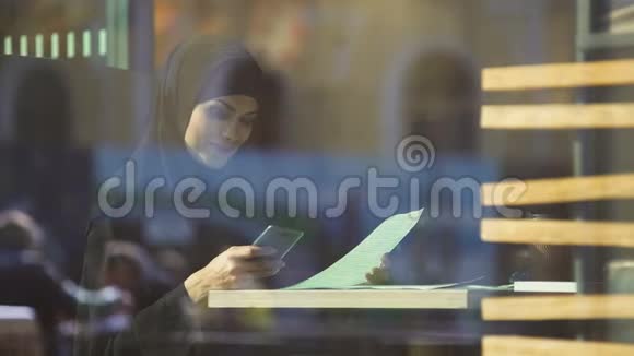 美丽的穆斯林女性自由职业者在咖啡馆里工作伴侣聊天视频的预览图