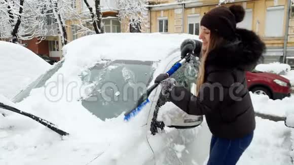 4k镜头微笑的年轻女子骑车上班前在雪地上擦车视频的预览图