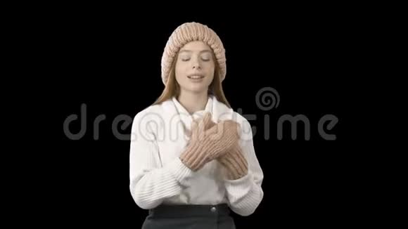 一个穿着粉色针织帽子和针织娃娃的红色长发的年轻女孩的愉悦和快乐的情绪把她折叠起来视频的预览图