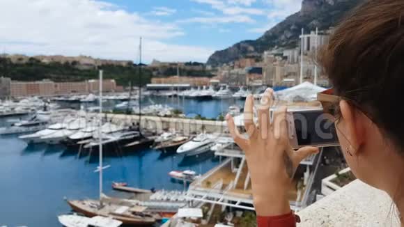 旅游女孩在地中海海港为游艇拍照使用智能手机视频的预览图