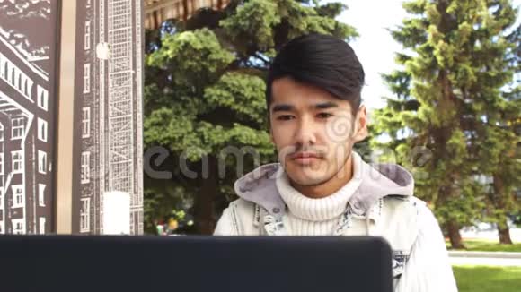 一个自由职业者坐在咖啡馆里在笔记本电脑上工作思考视频的预览图