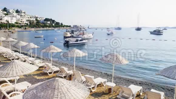 土耳其博德鲁姆度假小镇海岸的时间流逝海滩上的雨伞和太阳床游艇和船只视频的预览图